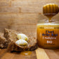 Miele millefiori Fiori delle Alpi con ambientazione in legno, abbinato con pane integrale e noci di burro