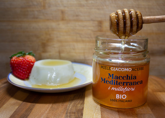 Miele millefiori Macchia Mediterranea con ambientazione in legno, abbinato con panna cotta e fragole