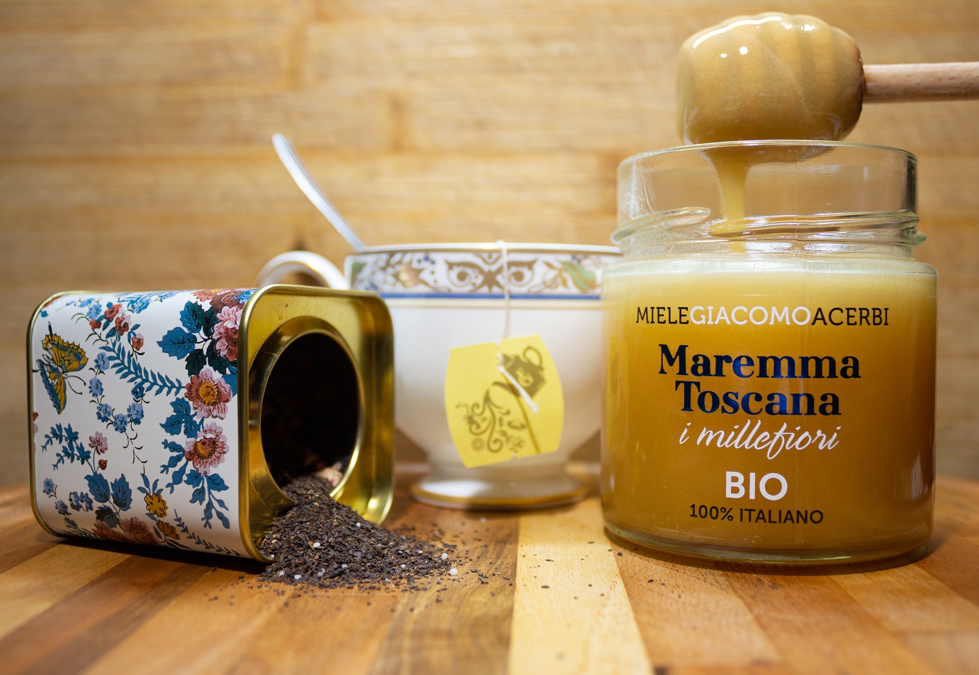 Miele millefiori Maremma Toscana con ambientazione in legno, abbinato con infuso e liquirizia
