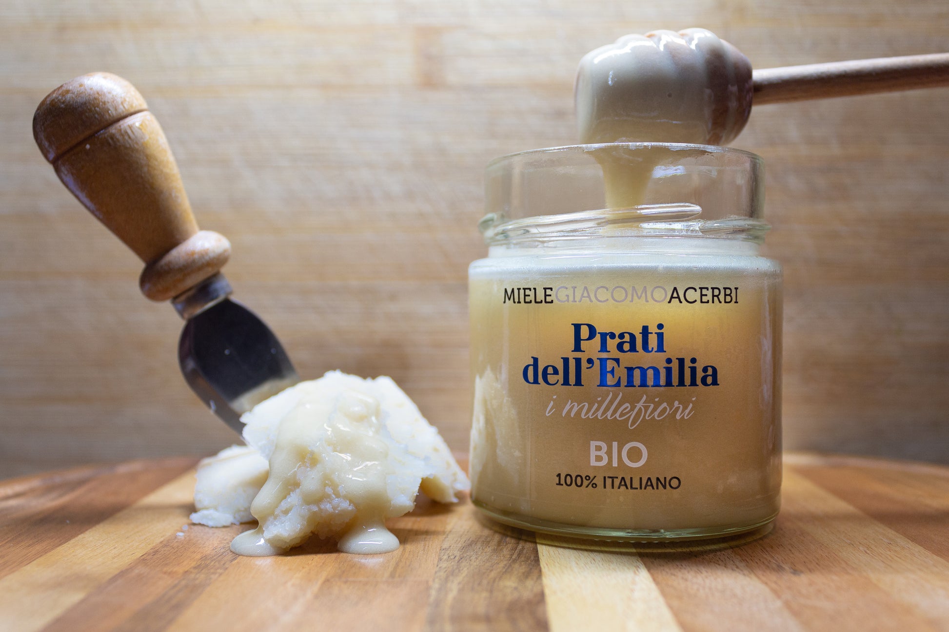 Miele millefiori Prati dell'Emilia con ambientazione in legno, abbinato con formaggio stagionato